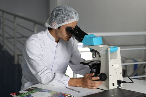 Pesquisador observando no microscópio e fazendo seu ensaio de materiais.
